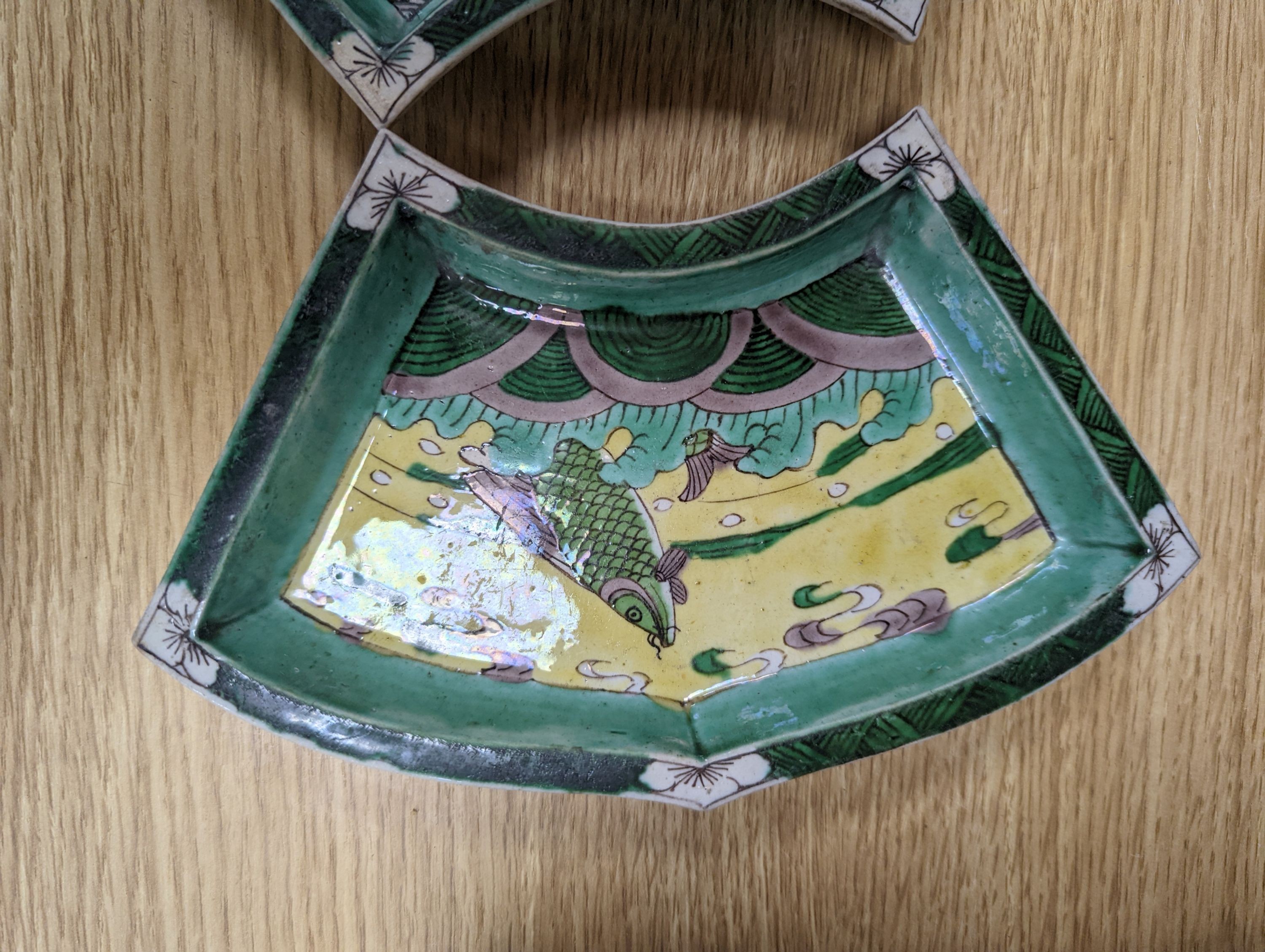 A pair of Chinese famille verte biscuit fan-shaped sweetmeat dishes, Kangxi, 20 cms wide.